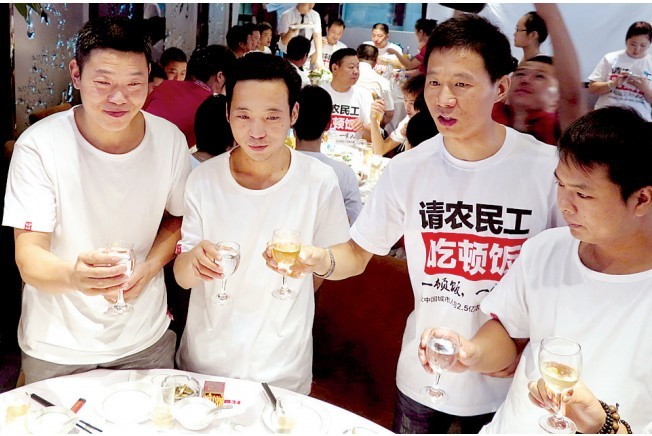 活動發(fā)起人張楠（右二）給農(nóng)民工敬酒。