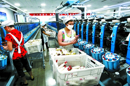 6月6日，舞鋼市鑫海紡織有限公司員工正在新建成的紡紗車間生產(chǎn)。