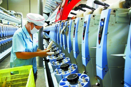 7月3日，在鄧州市永泰棉紡有限公司電腦控制全自動紡紗車間，紡織工人正在生產(chǎn)棉紗。