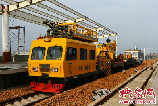一列工程車從站臺(tái)駛過(guò)。
