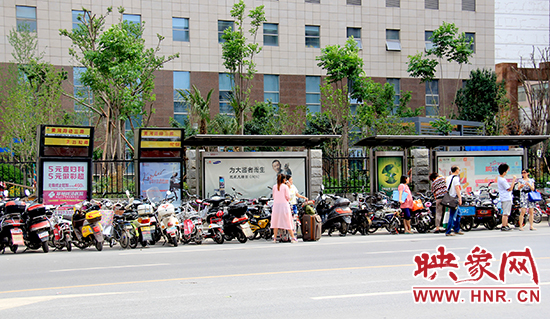 在黃河路經三路公交站牌候車的乘客被“擠”到了路上 在黃河路經三路公交站牌候車的乘客被“擠”到了路上