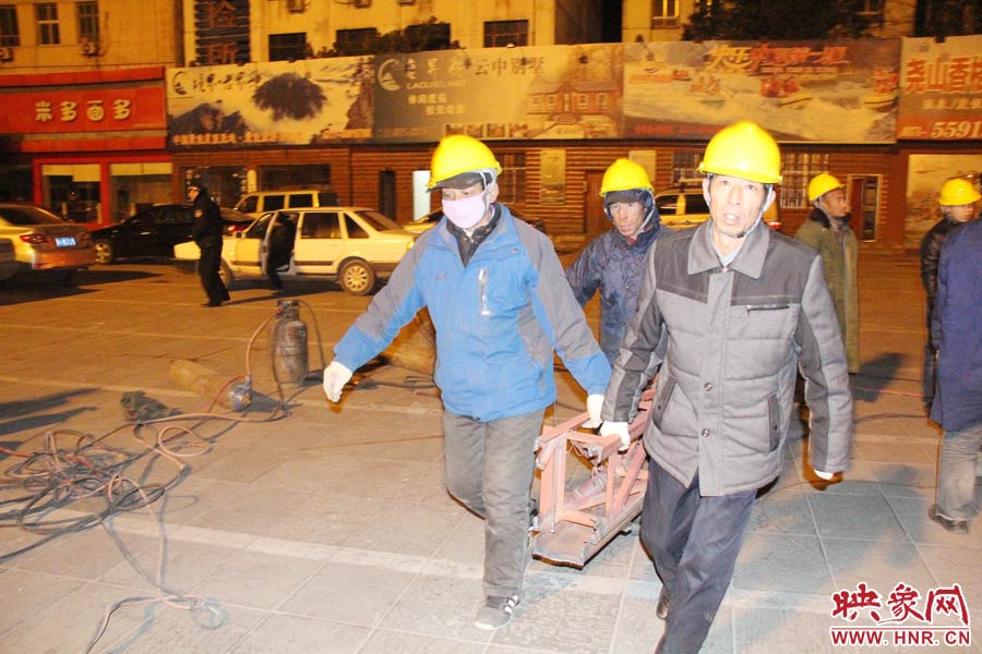 23點(diǎn)56分，第一塊兒廣告牌已經(jīng)分割完畢，地面上的20多名工人將拆除下來的鋼件撞車運(yùn)走。