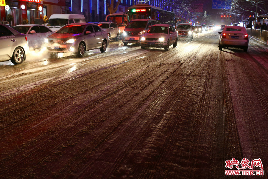 夜晚的雪路給出行的人們增加了困難。