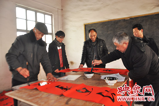 鞏義市魯莊鎮(zhèn)農(nóng)民書法愛好者正在寫春聯(lián)。