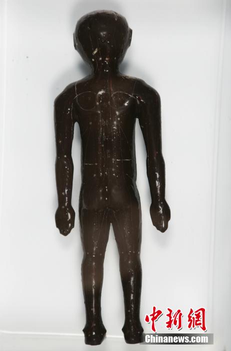 圖為出土的人體經(jīng)穴漆俑。