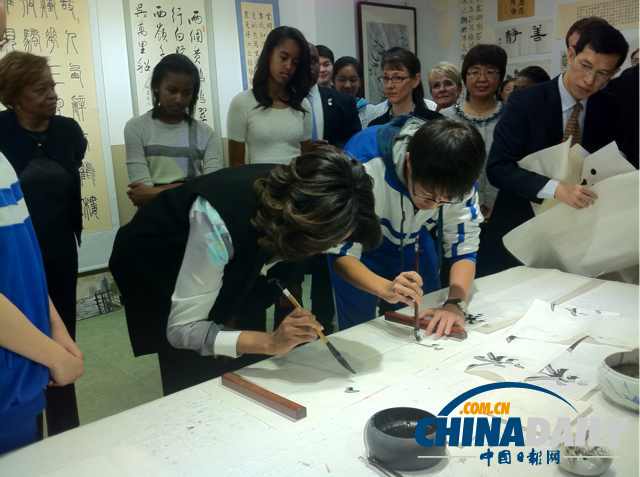 　北京時間3月21日，美國第一夫人米歇爾參觀北師大二附中時，與學生一起練習書法。