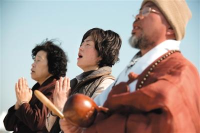 23日，一名僧侶引領(lǐng)人們?yōu)樗勒咂矶\。