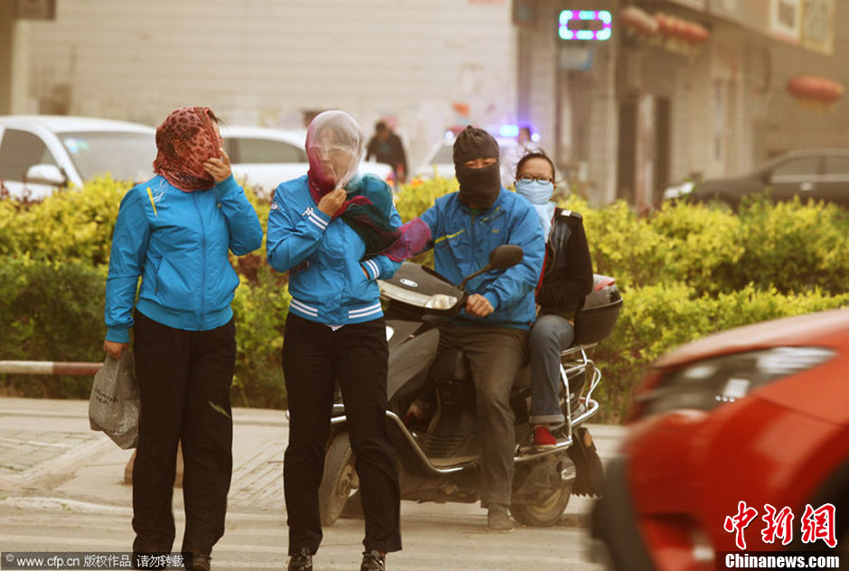 2014年04月23日，新疆維吾爾自治區(qū)吐魯番地區(qū)，市民戴著口罩行走在大風(fēng)沙塵中的吐魯番市街頭。