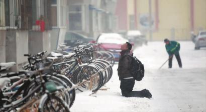 小伙子跪在樓前，一直抬頭看著樓上。 孫立國(guó)/攝