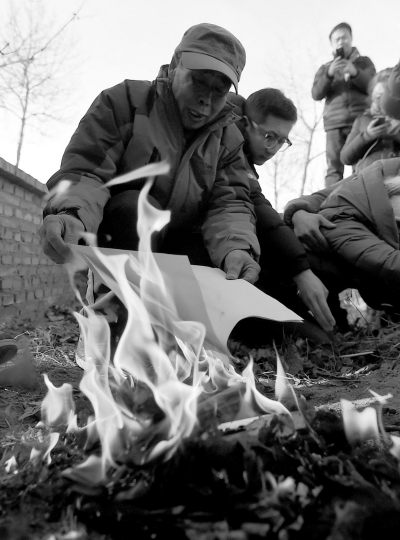 李三仁在兒子墳前焚燒再審無罪判決文書的復(fù)印件。新華社發(fā)