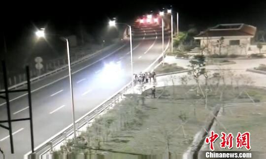 看到車輛經(jīng)過，孩子們便急忙跑到一旁的花圃上?！【焦﹫D　攝