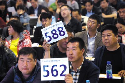 昨日，拍賣現(xiàn)場競拍者舉牌競拍。新京報記者