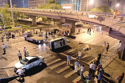 路虎沖下國貿(mào)橋砸中一輛起亞轎車，橋上厚達幾十厘米的水泥護欄被撞斷，碎石四處散落，數(shù)十群眾在現(xiàn)場圍觀。
