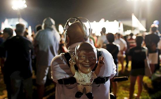 9月4日，新加坡，執(zhí)政黨的一場(chǎng)集會(huì)上，一名支持者背著一個(gè)李光耀的人偶。