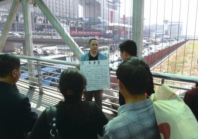 韓先生在北京西站天橋上籌錢。京華時(shí)報(bào)記者陶冉攝