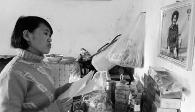 錢仁鳳站在母親遺像前。未能見母親最后一面是她的一大遺憾。