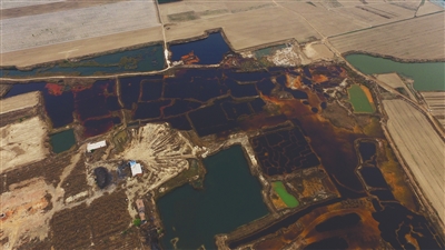 4月19日，廊坊市大城縣南趙扶鎮(zhèn)，津保路以北約八九百米處，一個(gè)巨大的污水坑中，水體呈現(xiàn)紅褐色。 新京報(bào)記者 尹亞飛 攝