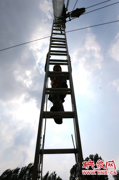 頂著太陽(yáng)的直射，檢修工不斷要爬上高處施工