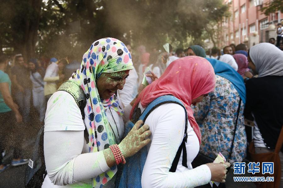 10月16日，在埃及首都開羅，兩名女青年在“彩色跑”活動中躲避人們拋撒的彩色粉末。