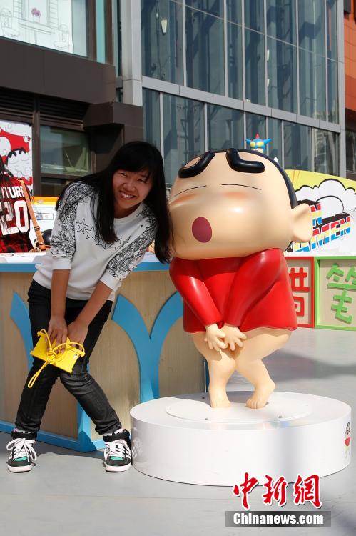 4月22日，游客與蠟筆小新合影?！跋灩P小新25周年紀(jì)念特展”日前在北京開展，吸引了不少市民游客。