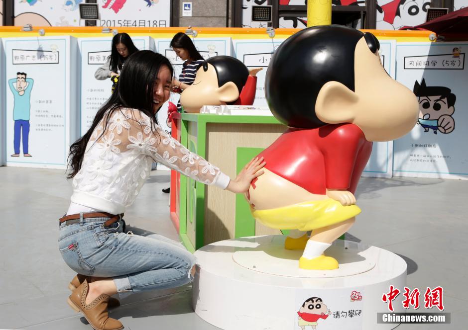 4月22日，游客與蠟筆小新合影?！跋灩P小新25周年紀(jì)念特展”日前在北京開展，吸引了不少市民游客。