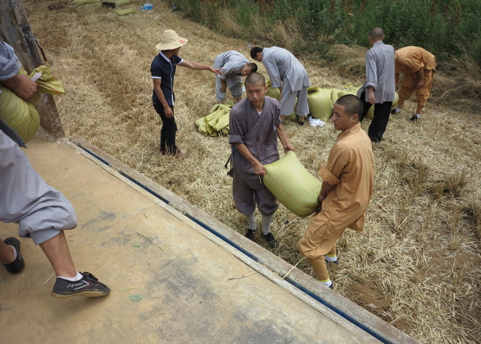 武僧將打包后的糧食集中至運(yùn)輸車輛上。