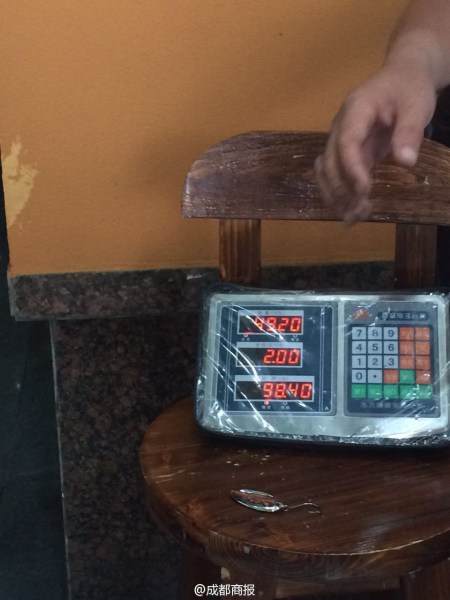 父子倆為大魚(yú)量體重。