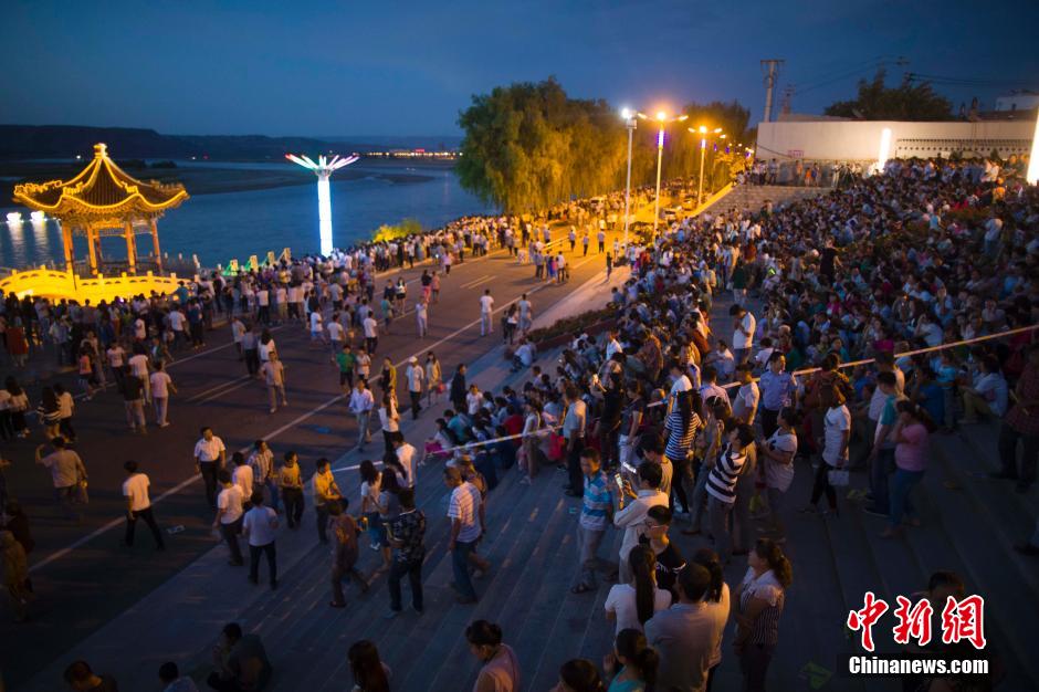 數(shù)萬民眾前來黃河邊觀看河燈。 張?jiān)?攝