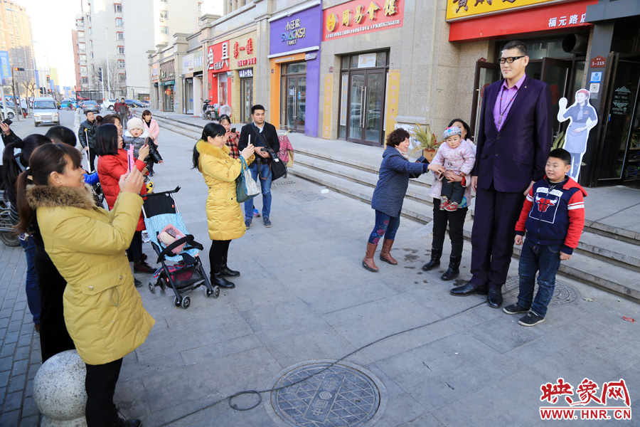 過(guò)路市民爭(zhēng)相與“巨人”合影。