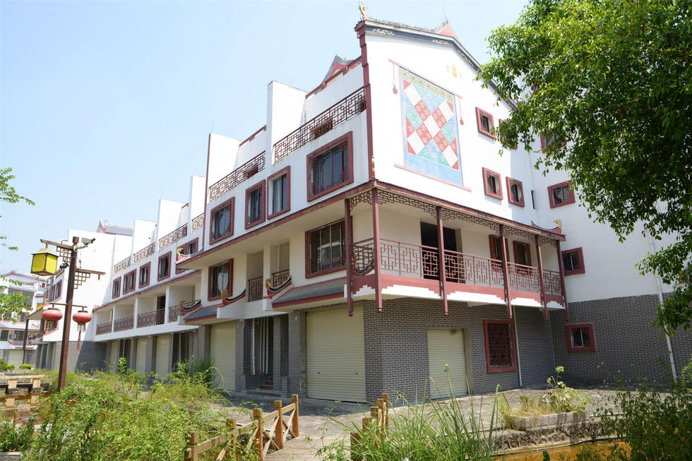 2016年7月26日，村民在廣西來賓市忻城縣隆達(dá)山水福城荒廢別墅間放牛。