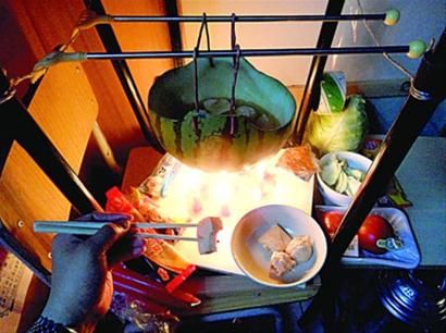 兩張椅子被面對面疊在一起，穿了兩根線的西瓜皮就懸空在椅腳中間，下面有蠟燭加熱，這就是西瓜火鍋。