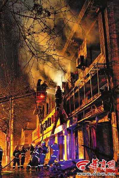 昨日22時(shí)10分，西安市豐慶路南小巷南口，消防官兵架梯子登上二樓施救 本組圖片由本報(bào)記者 閆文青 攝