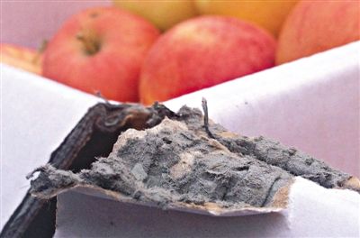 8月29日，新發(fā)地市場，一箱用“加重紙箱”包裝的蘋果正待售，紙箱夾層內(nèi)灰黑色的增重填充物清晰可見