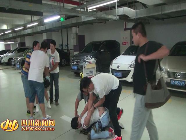 辦案人員在機(jī)場(chǎng)停車場(chǎng)抓獲胡某及其女友（警方視頻截圖）。