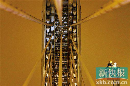 截至今日零時，男子仍未有下橋舉動。圖為公安和消防人員乘消防云梯在高空上和男子交談。