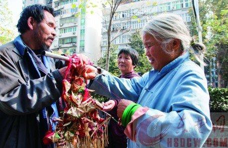 一個(gè)過(guò)路市民在挑選高廣林做的香包。