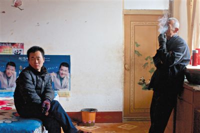 父親抽煙，兒子不語。逃跑的越南新娘，給袁迎賓父子帶來的是失落。新京報記者 周崗峰 攝