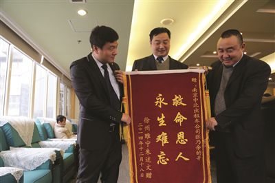 張乃余(中)和兩位救人的同伴一塊領(lǐng)獎。