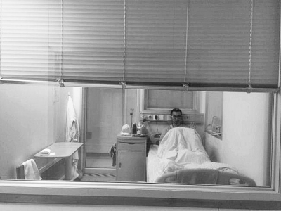 楊杰在醫(yī)院隔離病房中，沖記者揮了揮手。