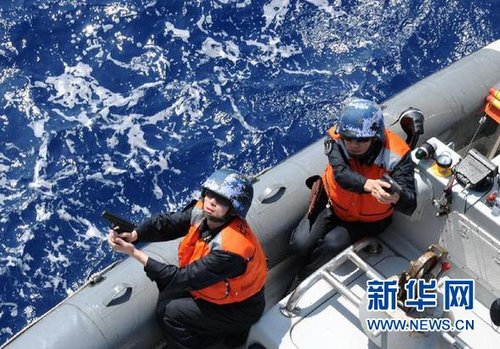 　3月28日，十余名臨檢拿捕隊員乘小艇駛至模擬可疑商船下方水面。