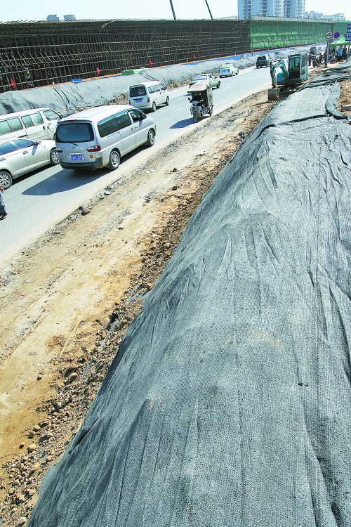 豐樂路與北三環(huán)交叉口，修路的土被歸置得整整齊齊，并用黑網(wǎng)覆蓋，既保暢通又避免了揚塵。