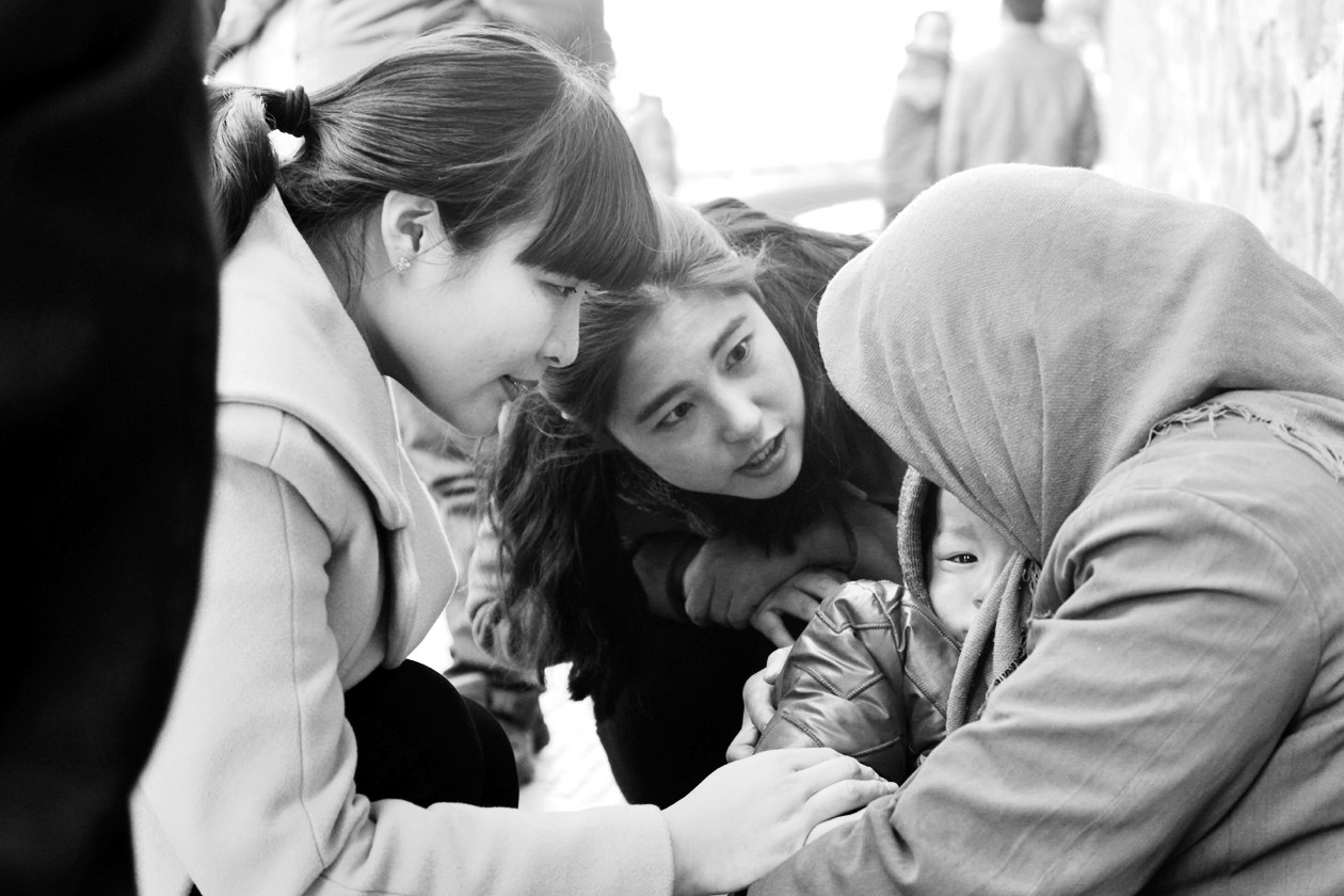 “幫女郎”(左)和“小莉”發(fā)現(xiàn)乞討男童后，上前近距離進行辨認