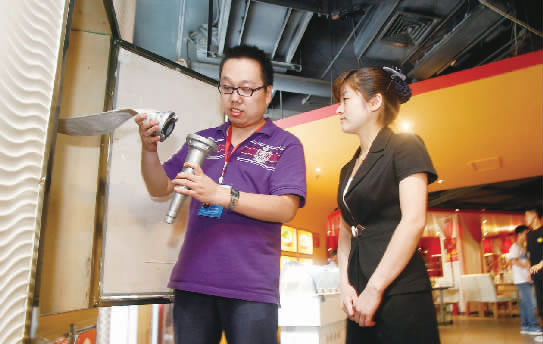 鄭州市經八路街道辦事處建文社區(qū)網格負責人王楠（左）在轄區(qū)內的飯店檢查消防設施