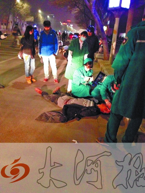 醉漢躺在地上，醫(yī)護(hù)人員對其進(jìn)行檢查。